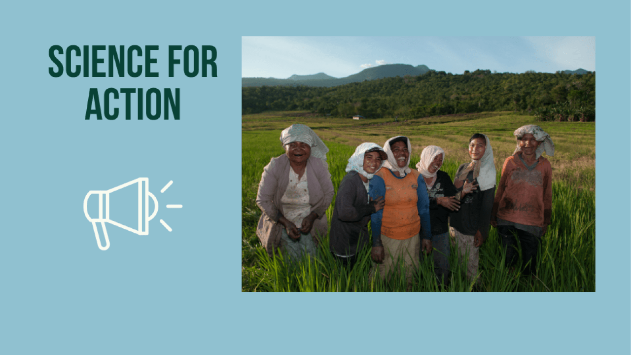 six women smiling in field with mountains in the background