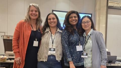 Four women posing at a conference