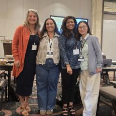 Four women posing at a conference