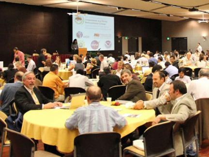 Conference attendees sitting at round tables at the first Open Science Meeting