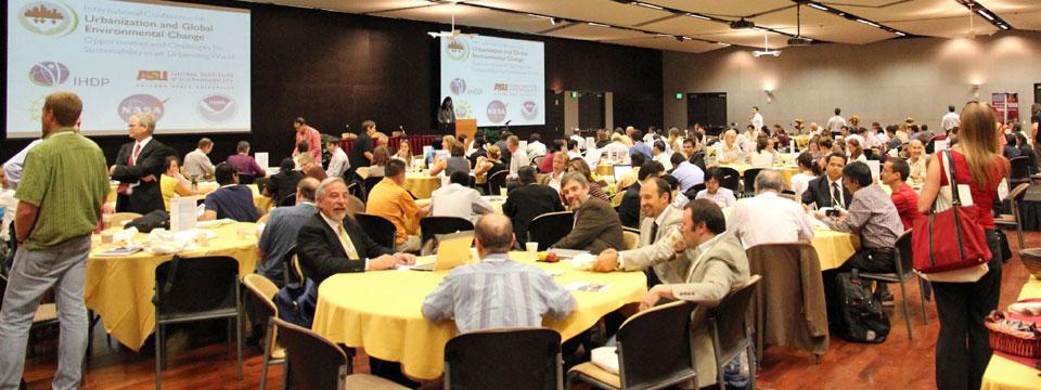 Conference attendees sitting at round tables at the first Open Science Meeting